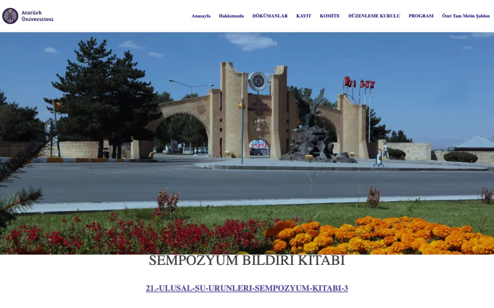 Atatürk Üniversitesi kampüs giriş kapısının, önündeki çiçeklerin ve üst menünün yer aldığı web sayfası ekran görüntüsü. Alt kısımda 'SEMPOZYUM BİLDİRİ KİTABI' başlığı ve bir bağlantı metni bulunuyor.